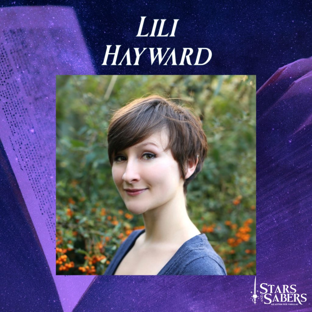 Stars and Sabers Author Lili Hayward, with short brown hair and wearing a blue shirt.